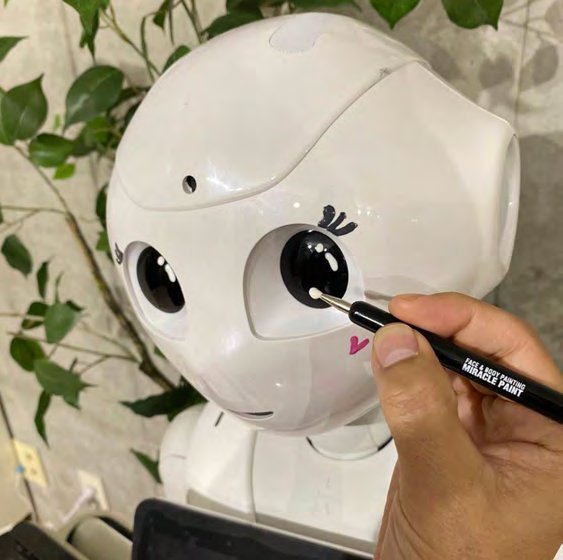 Pepperの目元にペンで描き込む様子